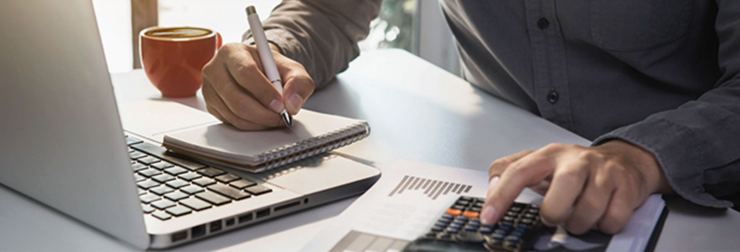 Persona revisando documentos fiscales con calculadora y portátil